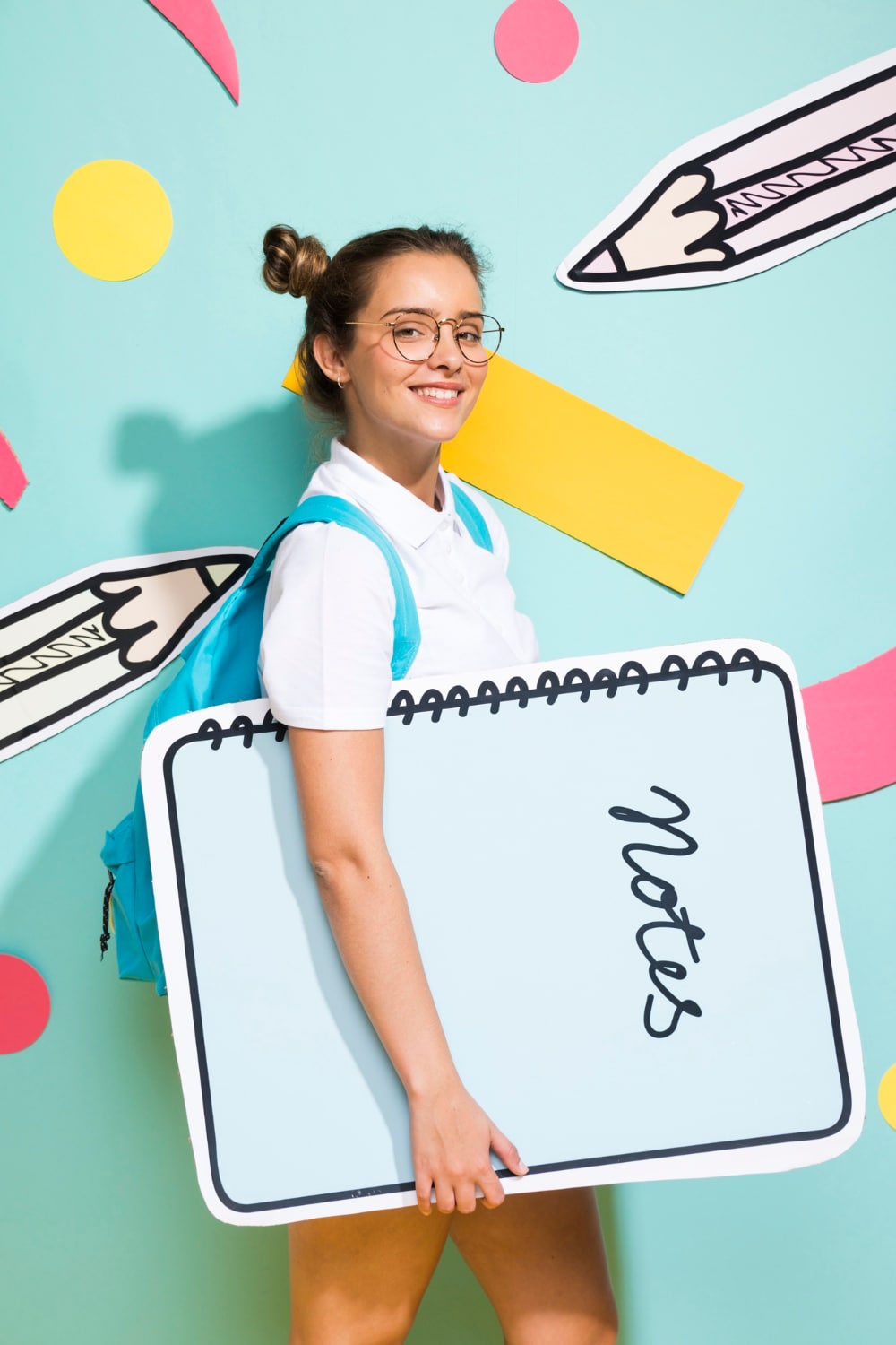 Une adolescente souriante qui va à l'école avec un grand cahier sous le bras