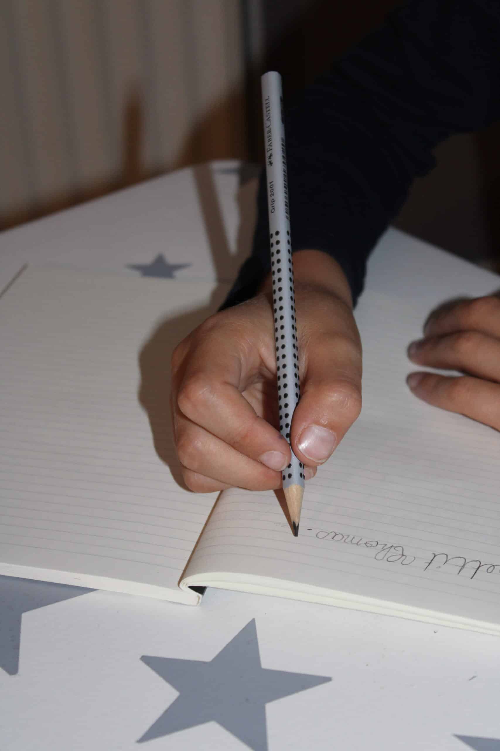 La position des doigts sur le crayon est importante. Le crayon est en appui dans la commissure pouce index et dans l'axe de l'avant-bras. Il est tenu entre la pulpe du pouce et le côté de la dernière phalange du majeur. L'index qui doit être souple, vient se poser sur le crayon.